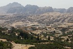 Here you can see the town of Wadi Musa (Valley of Moses) in the foreground. The historic city of Petra lies between the two mountain ranges in the background. If you know where to look (just left of the center, in the closest mountain range) you can see the Siq (shaft/canyon) that cuts through the mountains and leads to Petra. : Jordan