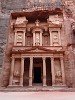 The Treasury (Al-Khazneh)  The Treasury (or locally known as Al-Khazneh) is probably the best known structure of the ancient city of Petra. It was carved out of the iron-rich sandstone rock to serve as a tomb for the Nabataean King Aretas III, probably somewhere between 100 BC and AD 200. The name Treasury is derived from a legend that bandits hid their loot in a stone urn high on the second level. Significant damage from bullets can be seen on the urn. Local lore attributes this to Bedouins, who are said to have shot at the urn in hopes of breaking it open and spilling out the "treasure" within (the decorative urn, however, is solid sandstone). Another story is that it functioned as a treasury for the Egyptian Pharaoh at the time of Moses. As with all the monuments in Petra, it's the facade that captivates, the interior is just an unadorned square hall with a smaller room in the back. The Treasury is 43m high and about 30m wide. I took this image a few minutes after sunset. : Jordan