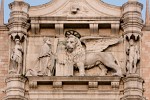 The figure of Doge Francesco Foscari kneeling before the winged lion - the symbol of St Mark - on the Westside of Palazzo Ducale in Venice, Italy. The legend says that if the book, held by lion, is open it is the time of peace and when the book is closed (no negotiations) it is the time of war. : Italy